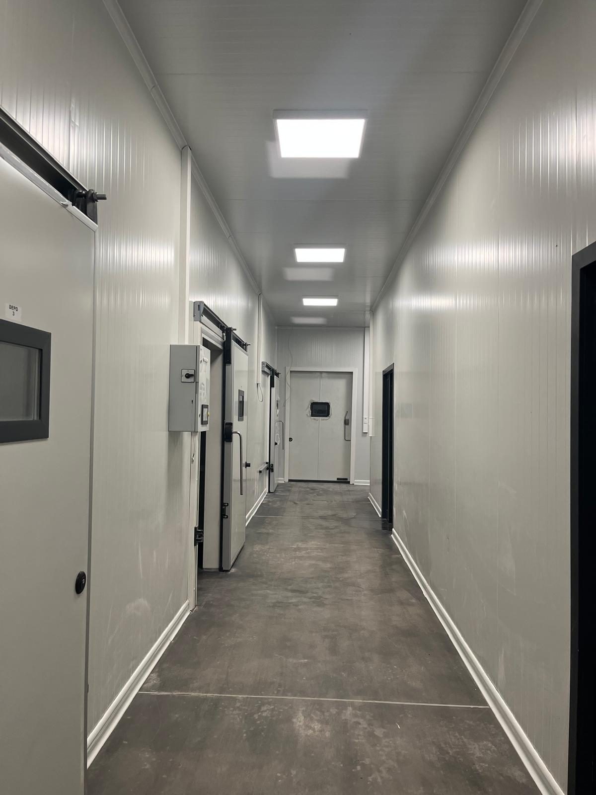 A corridor with white sliding doors. This photograph does not confirm the printed size chart.