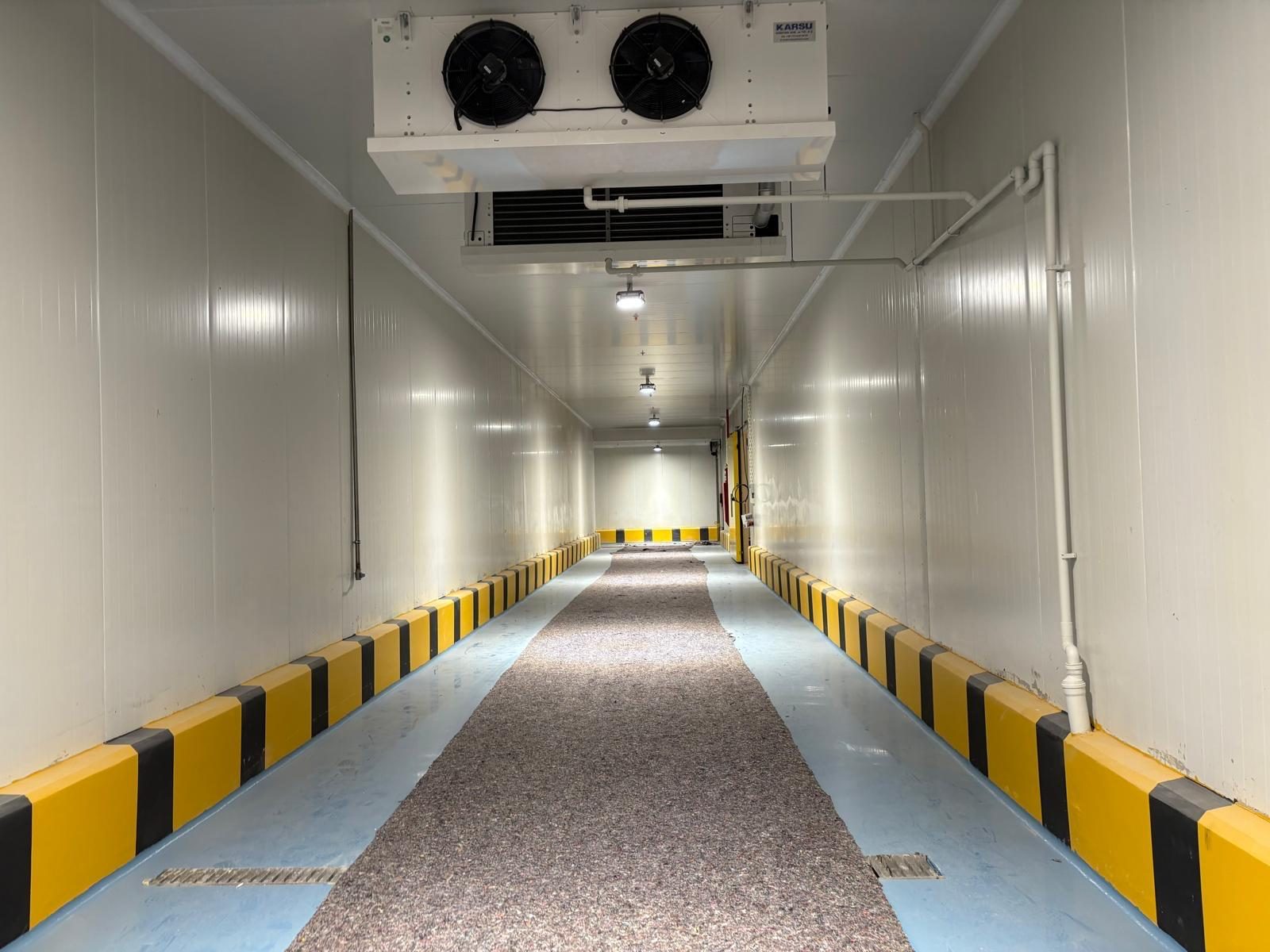 Panel-lined corridor with an overhead cooling unit.